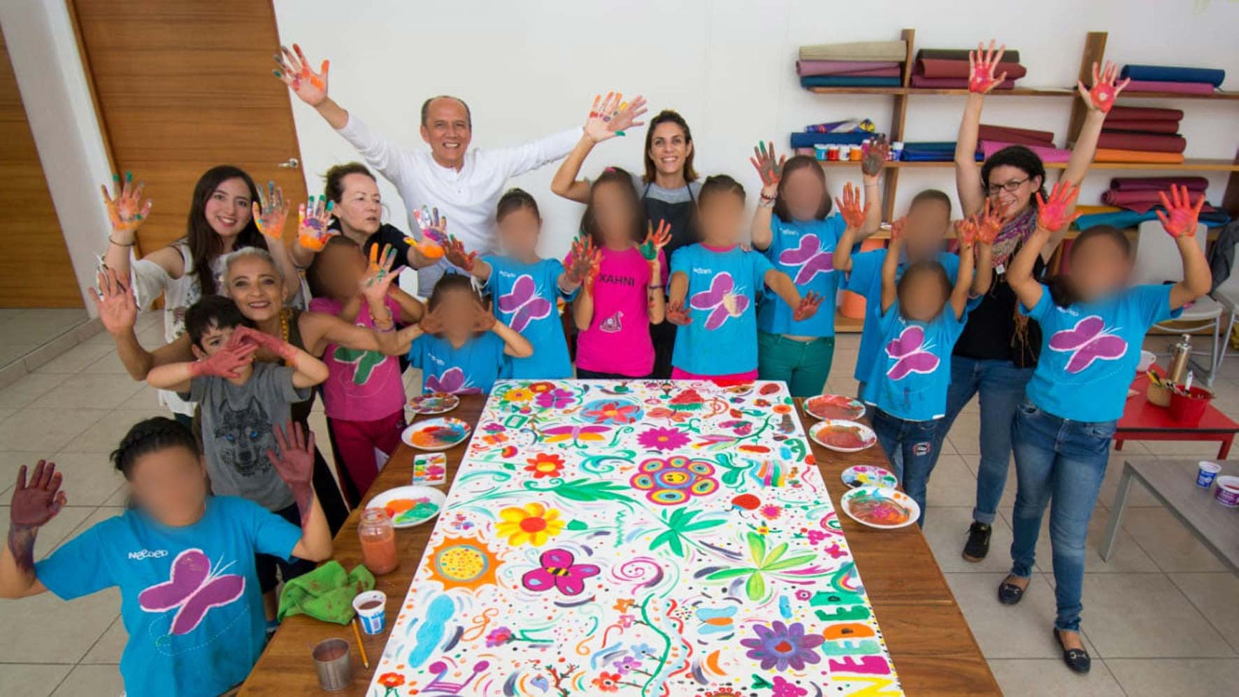 Las niñas sonriendo en frente de un dibujo que pintaron juntos